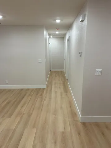 an empty room with window ceiling fan and wooden floor