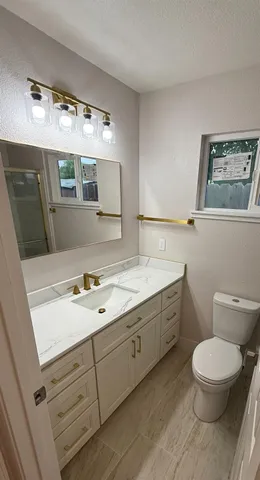 a view of an empty room with wooden floor and ceiling fan