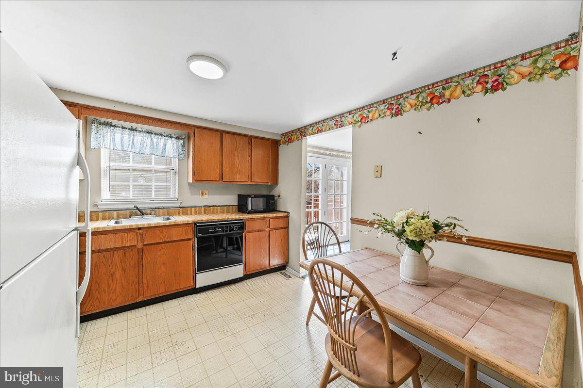 15 Colonial Circle Aston, PA 19014 - Photo 5 of 30 a kitchen with sink refrigerator dining table and chairs