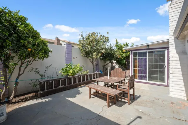 a view of a patio with table and chairs with wooden fence and plants