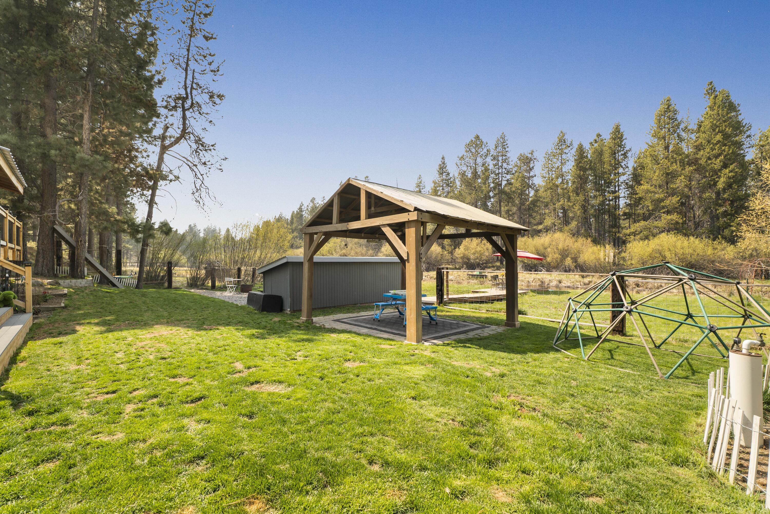 17062 Milky Way Bend, OR 97707 - Photo 23 of 39 Timber-frame pavilion, climbing dome, and fenced lawn ? the family compound