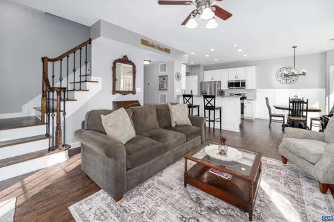 a living room with furniture kitchen view and a chandelier