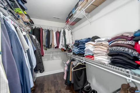 a view of walk in closet with clothes and shoes