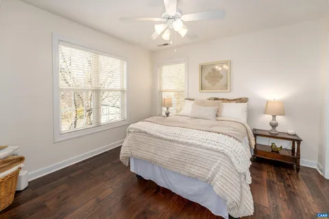 a bedroom with a bed wooden floor and window