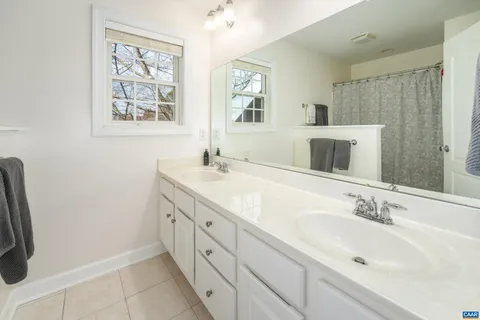a bathroom with double sink and a mirror
