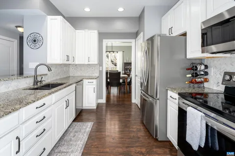 a kitchen with stainless steel appliances granite countertop a refrigerator and a stove top oven