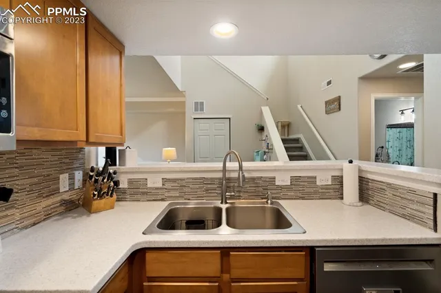 a kitchen with a sink a counter space and cabinets