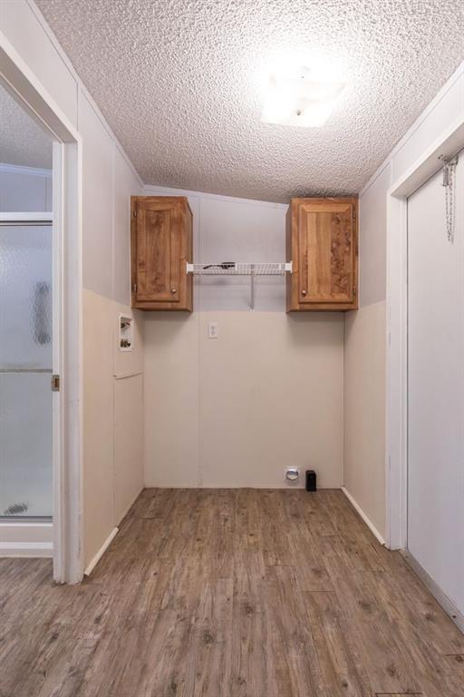 717 Marlin Street Clyde, TX 79510 - Photo 21 of 37 an empty room with wooden floor and cabinet