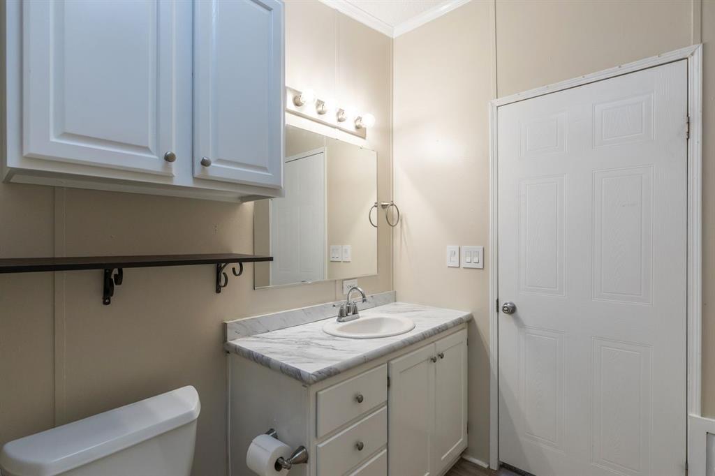 717 Marlin Street Clyde, TX 79510 - Photo 23 of 37 a bathroom with a granite countertop sink and a mirror
