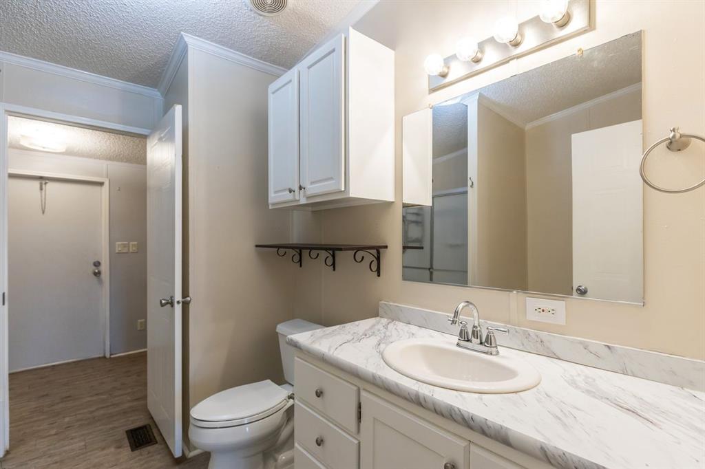 717 Marlin Street Clyde, TX 79510 - Photo 26 of 37 a bathroom with a granite countertop toilet sink and mirror