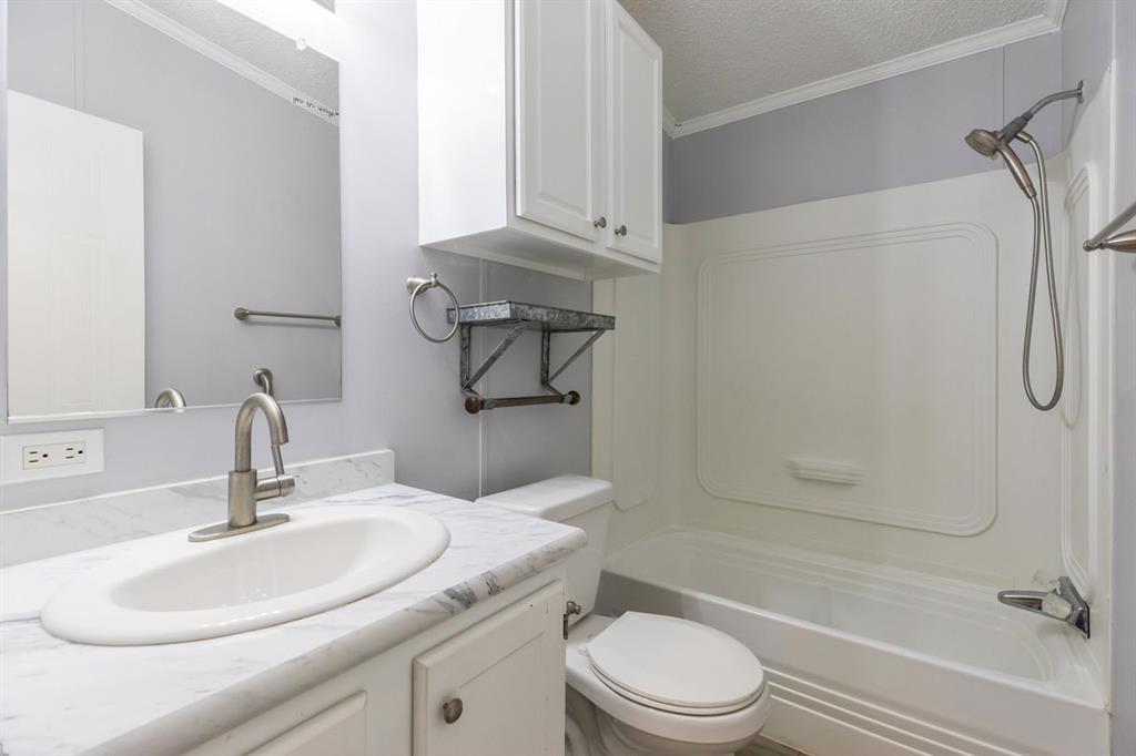 717 Marlin Street Clyde, TX 79510 - Photo 33 of 37 a bathroom with a granite countertop sink toilet and shower