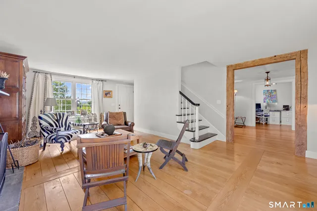 a living room with furniture a wooden floor and a large window