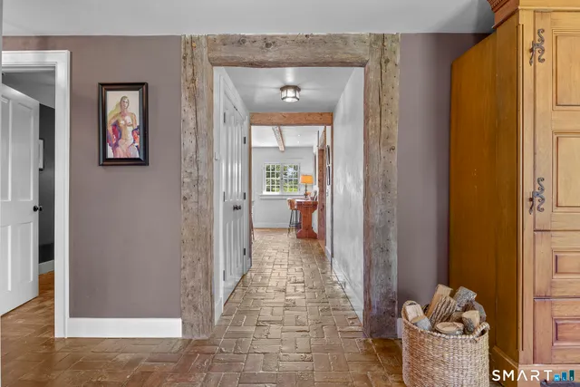 a view of a hallway with wooden floor and a livingroom