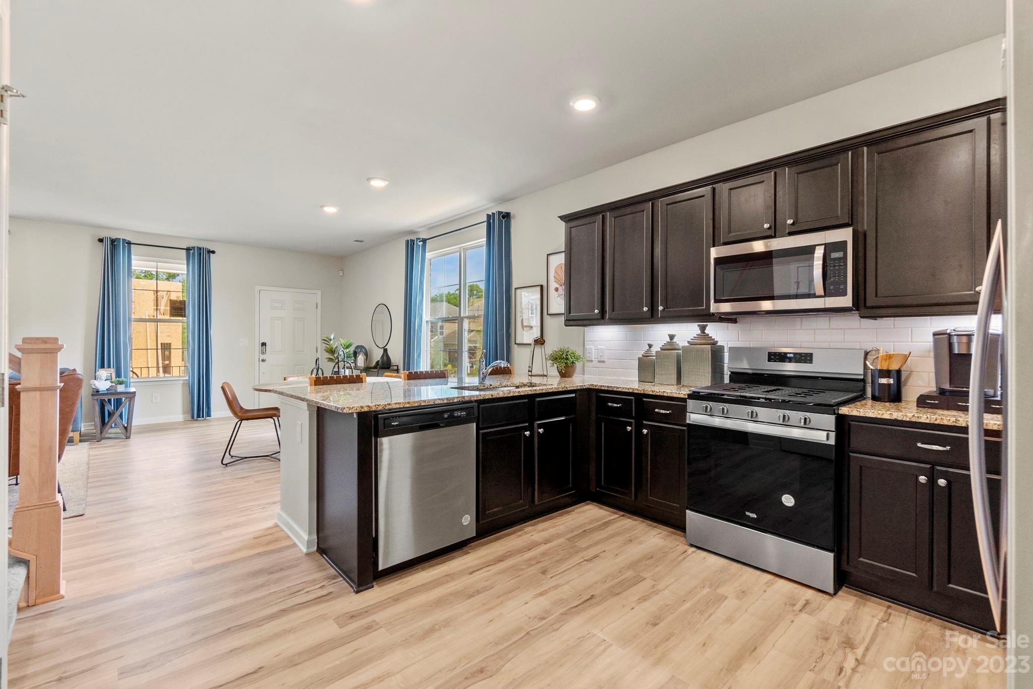 7856 Nelson Road Mint Hill, NC 28227 - Photo 9 of 30 a kitchen with stainless steel appliances kitchen island granite countertop a stove top oven and sink