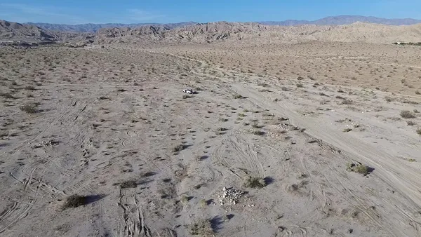 a view of a dry field with a mountain in the background