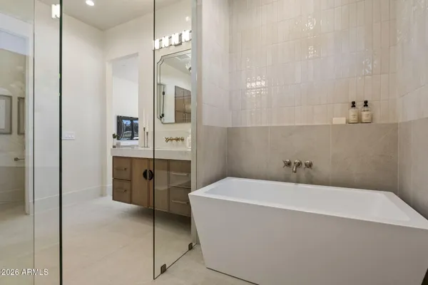 a en suite bathroom with a granite countertop sink and a mirror