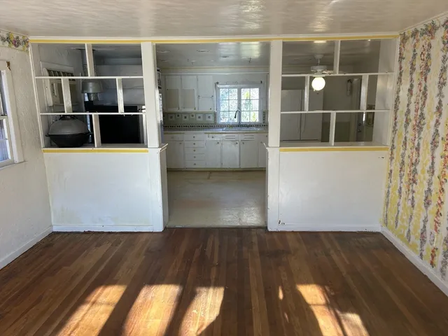 a view of a living room with wooden floor and a floor to ceiling window