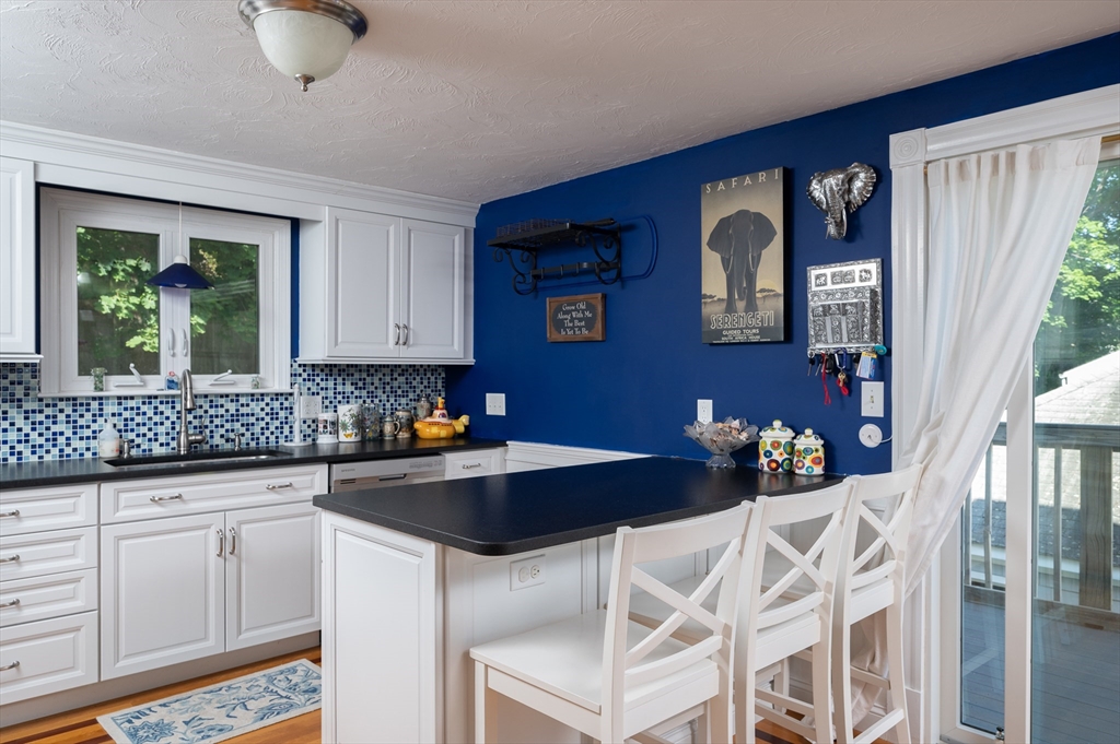 29 Wituwamat Road Weymouth, MA 02191 - Photo 11 of 42 a kitchen with granite countertop a sink chairs and cabinets