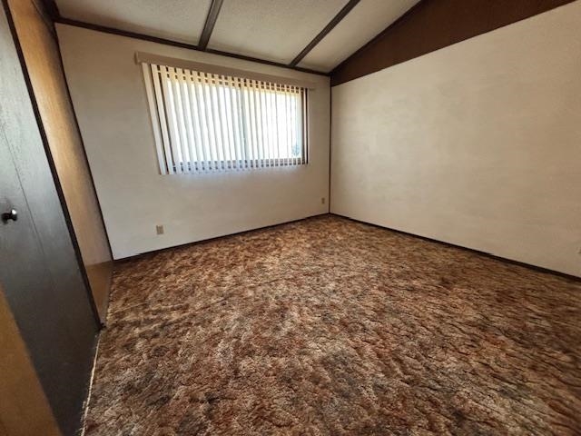 11452 Cooper Road Chisholm, MN 55719 - Photo 9 of 14 Spare room with dark colored carpet and lofted ceiling