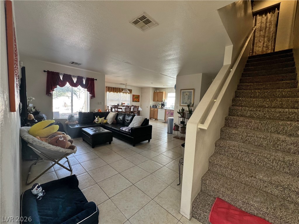 5698 Doubleday Street Las Vegas, NV 89118 - Photo 11 of 24 Living area with plenty of natural light, a textured ceiling, and light tile patterned flooring