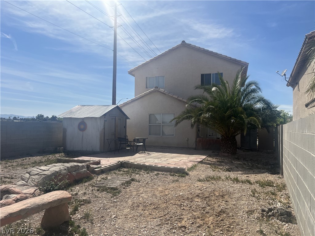 5698 Doubleday Street Las Vegas, NV 89118 - Photo 16 of 24 Rear view of property with a patio area, a fenced backyard, a shed, and stucco siding