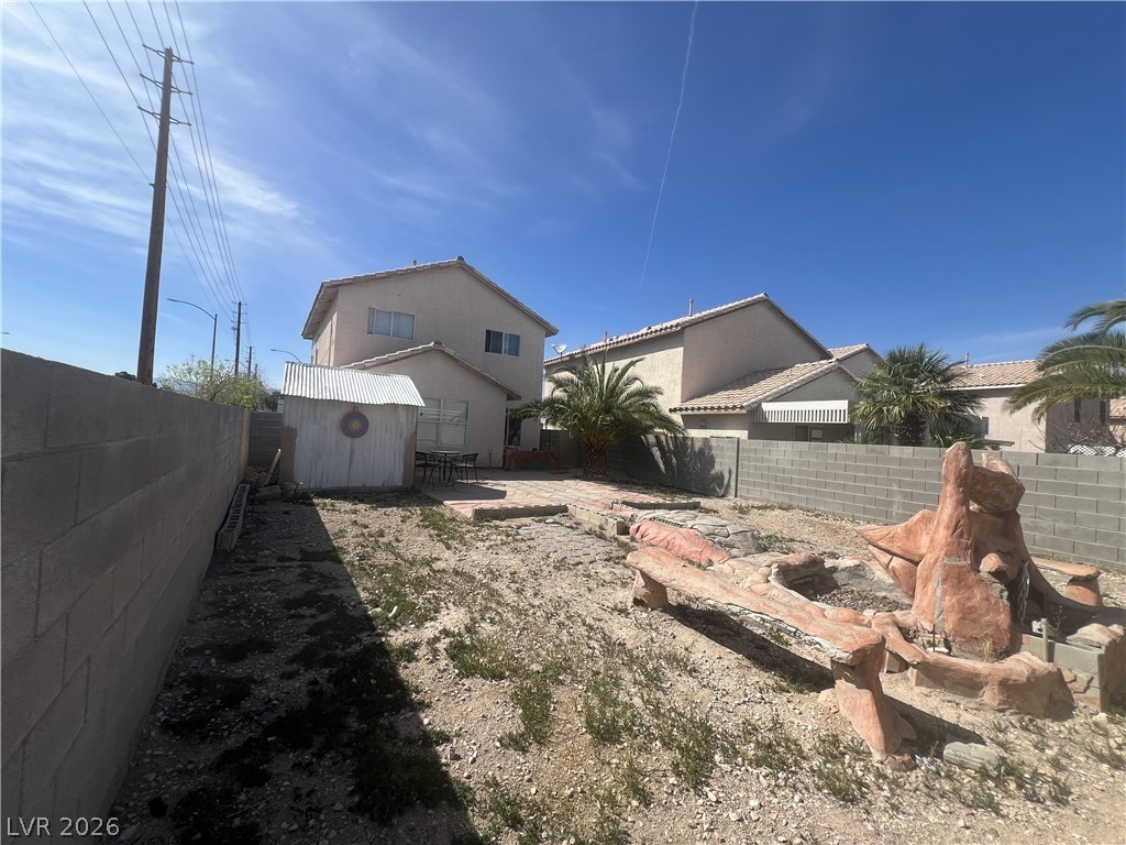 5698 Doubleday Street Las Vegas, NV 89118 - Photo 17 of 24 Rear view of house with a fenced backyard, a shed, stucco siding, and a patio area
