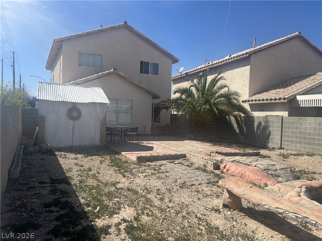 5698 Doubleday Street Las Vegas, NV 89118 - Photo 18 of 24 Back of house featuring a patio area, a fenced backyard, stucco siding, and a shed