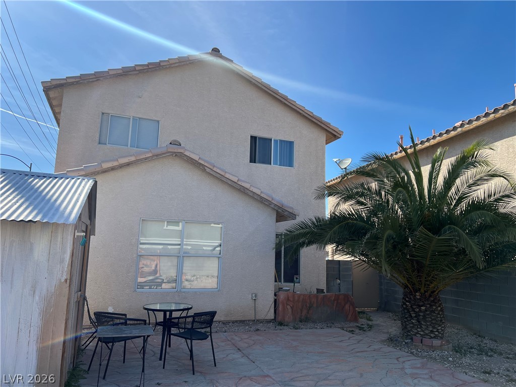 5698 Doubleday Street Las Vegas, NV 89118 - Photo 22 of 24 Rear view of property with stucco siding, a patio, and outdoor dining area