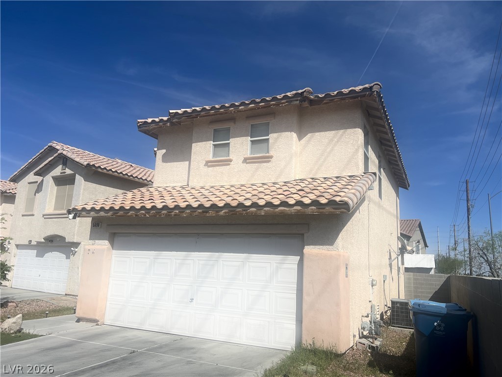 5698 Doubleday Street Las Vegas, NV 89118 - Photo 4 of 24 Mediterranean / spanish-style house featuring a garage, stucco siding, and concrete driveway