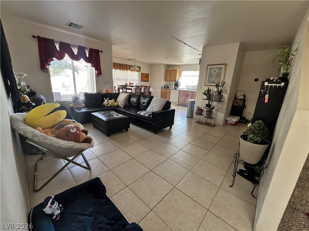5698 Doubleday Street Las Vegas, NV 89118 - Photo 10 of 24 Living area with plenty of natural light, light tile patterned floors, and a textured ceiling