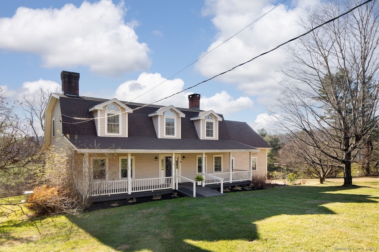 a front view of a house with a garden and trees