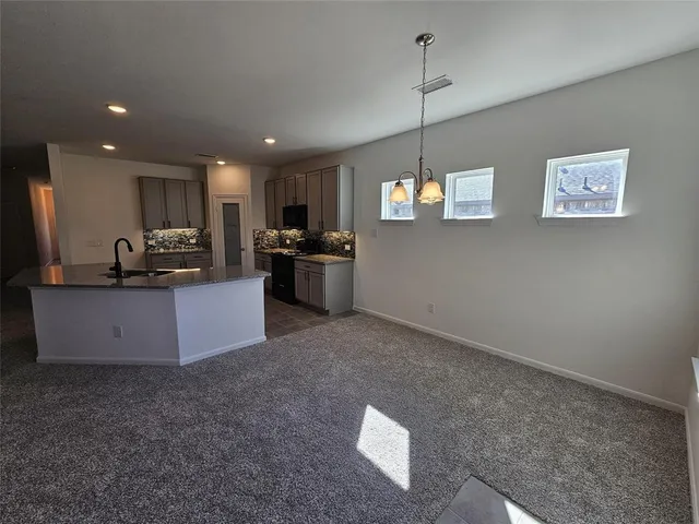 a kitchen with stainless steel appliances granite countertop a refrigerator a sink a stove a microwave and wooden floor