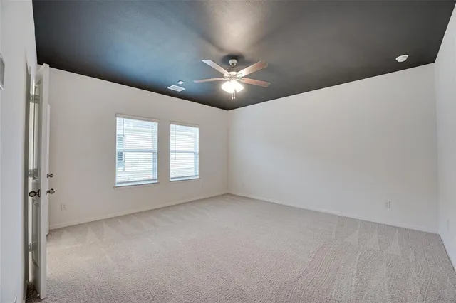 an empty room with a ceiling fan and a window