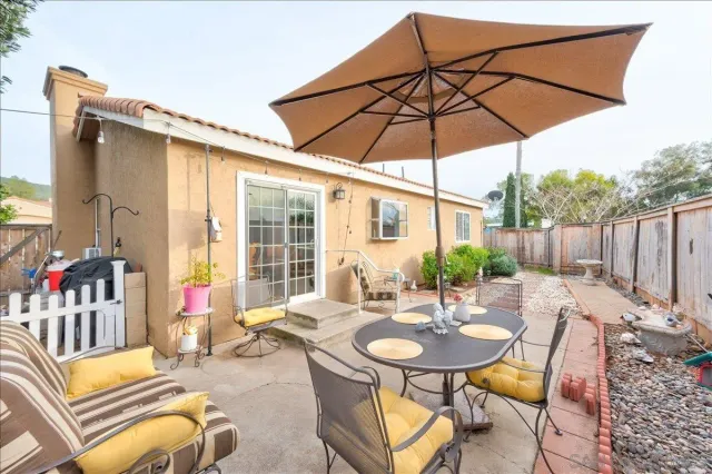a view of a patio with table and chairs with wooden fence and plants