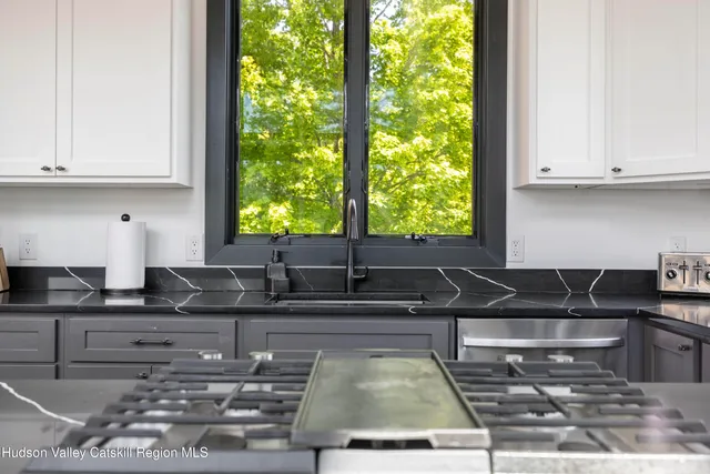 a living room with furniture a flat screen tv and a kitchen view