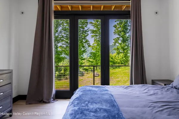 a bedroom with a large bed and a flat tv screen on dresser
