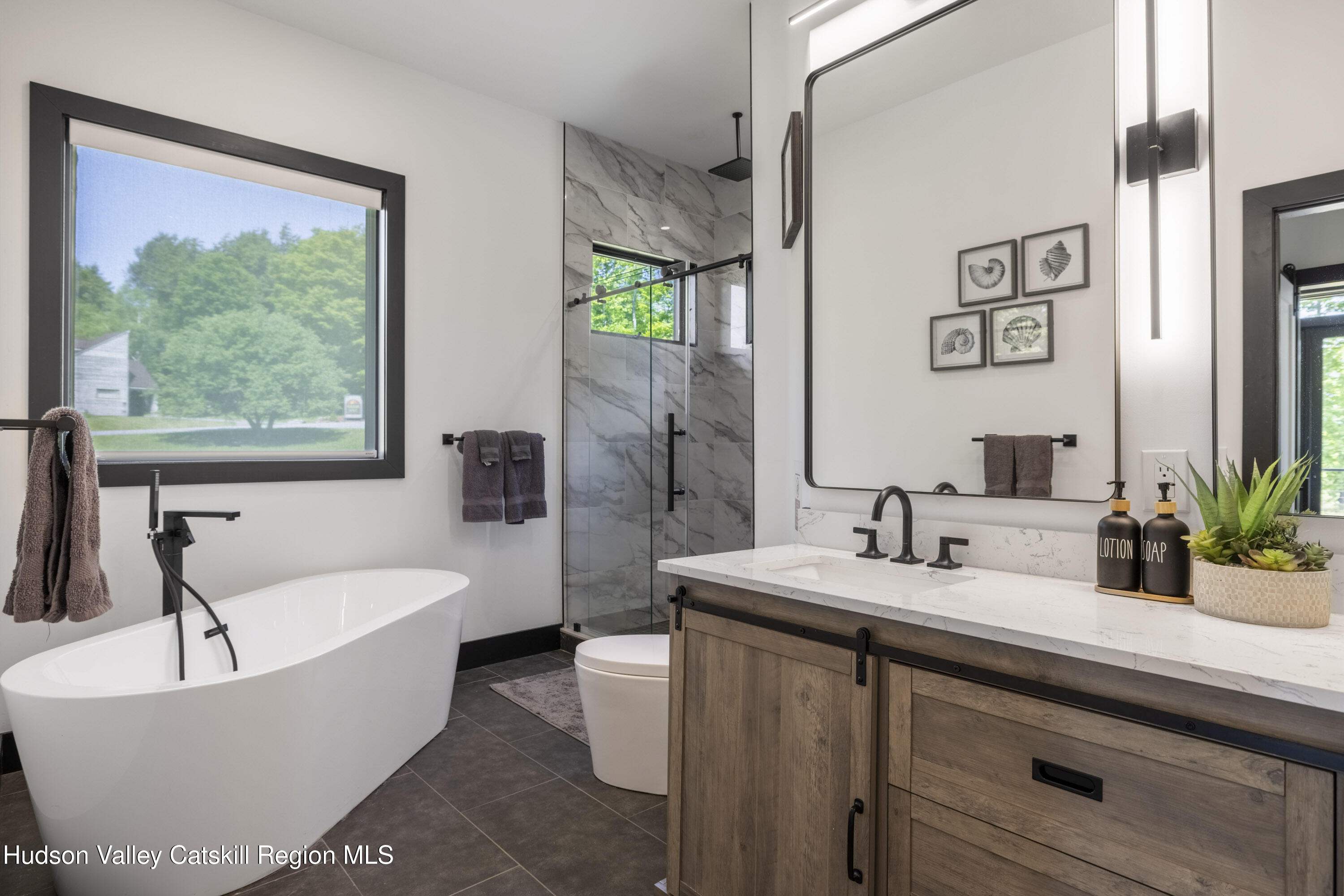4 Goff Road Windham, NY 12496 - Photo 18 of 68 a bathroom with a bathtub a sink and a large mirror