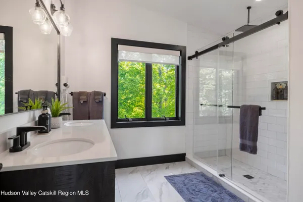a view of a hallway with bathroom and a glass door shower