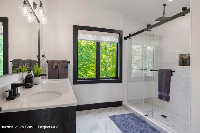 a view of a hallway with bathroom and a glass door shower