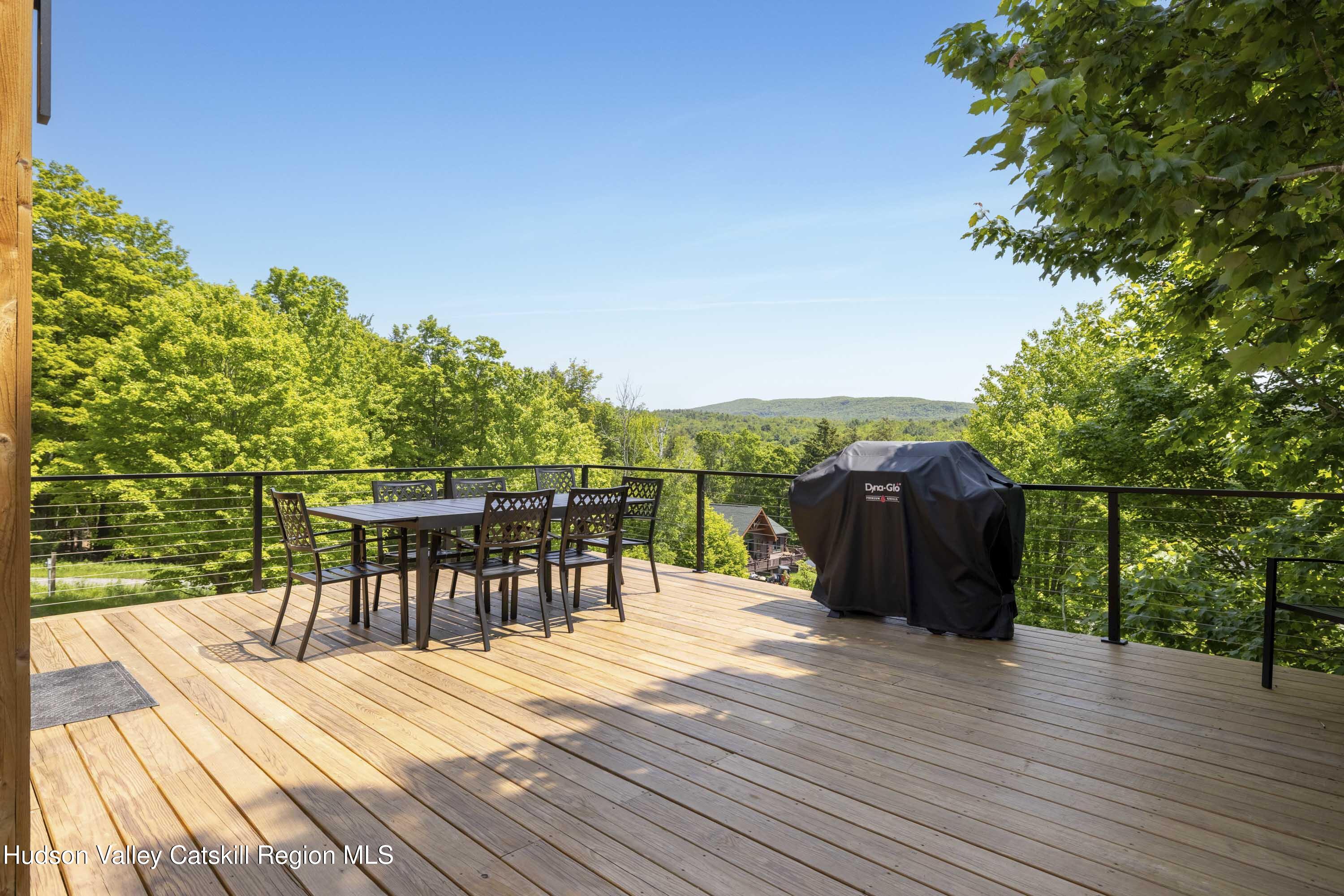 4 Goff Road Windham, NY 12496 - Photo 49 of 68 a view of a roof deck with table and chairs with wooden floor and fence