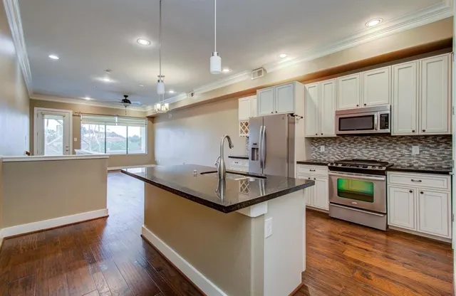 a kitchen with stainless steel appliances granite countertop a sink stove and refrigerator