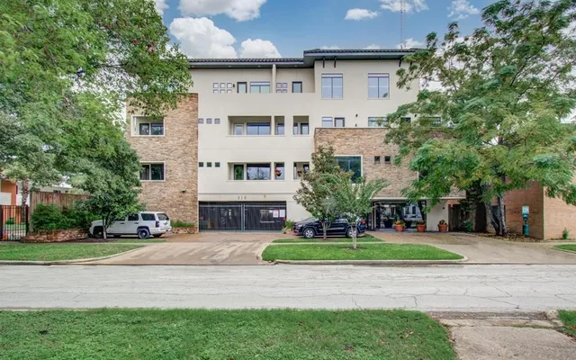 a front view of a house with a yard and trees