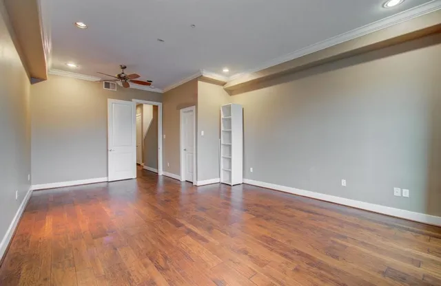 a view of an empty room with wooden floor