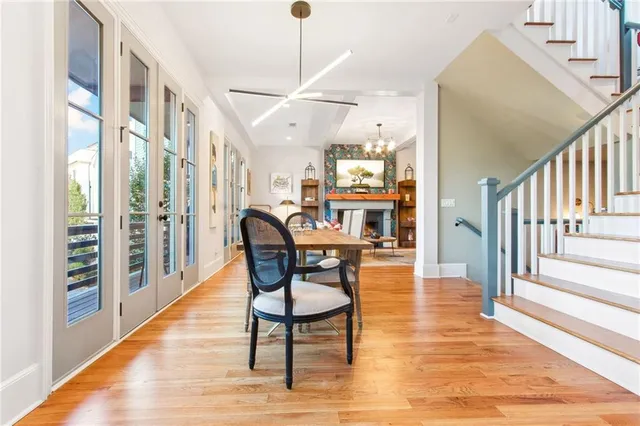 a dining room with wooden floor a chandelier a wooden table and chairs