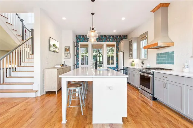 a kitchen with stainless steel appliances granite countertop a stove and a wooden floors