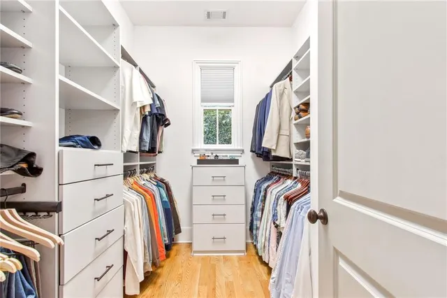 a view of walk in closet with clothes and shoes