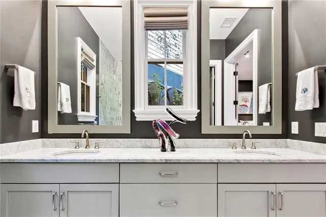 a bathroom with double vanity sinks and a mirror