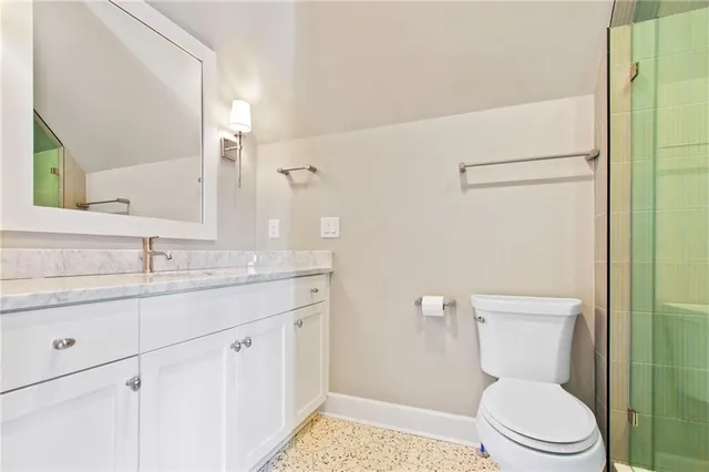 a bathroom with a granite countertop sink toilet and shower