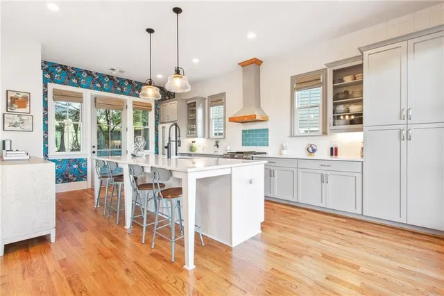a kitchen with kitchen island granite countertop wooden floors and white cabinets