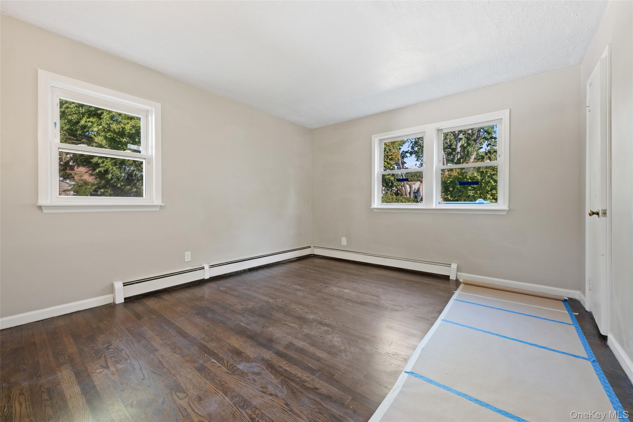 40 Duke Street Deer Park, NY 11729 - Photo 13 of 15 Spare room with dark wood-style floors and a baseboard heating unit
